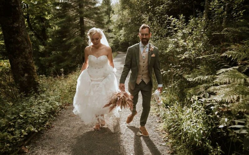 Walking to the waterfall as the bride and groom at High Force Hotel in County Durham for their bespoke wedding