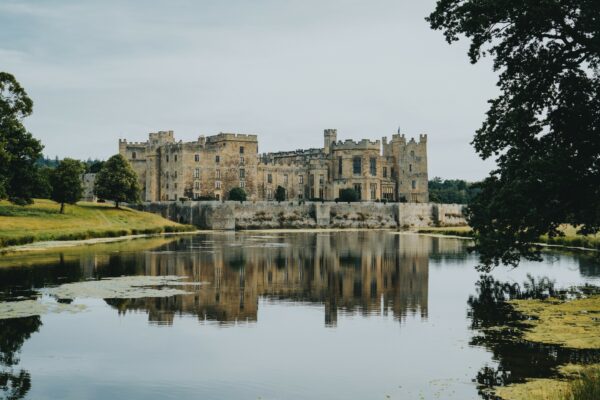 Historic Raby Castle in County Durham Majestic medieval Raby Castle with stone walls, battlements, and towers set against a clear blue sky.
