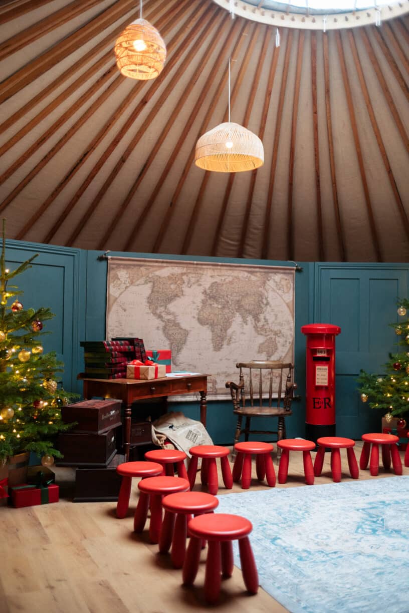 Children meeting Mr and Mrs Claus inside a festive, twinkling yurt at Raby Castle, surrounded by lights, decorations, and holiday cheer.