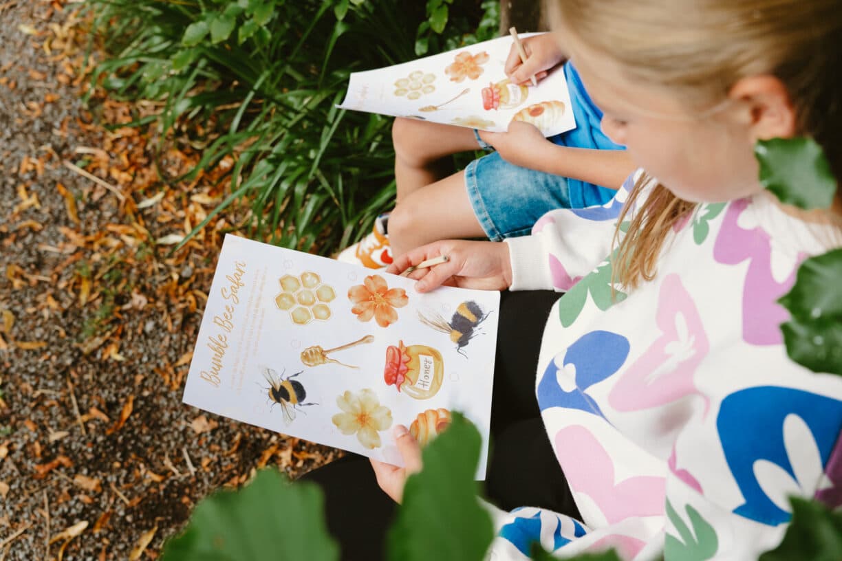 Children taking part in the Little Bumble Bees’ Trail at High Force Waterfall, exploring a woodland path while searching for bee-themed clues and honey pots.